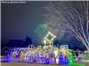 A lit up Christmas display in front of a house.  