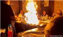 Food preparer uses fire in presentation to seated customers. 