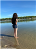 Woman standing in shallow river water. 
