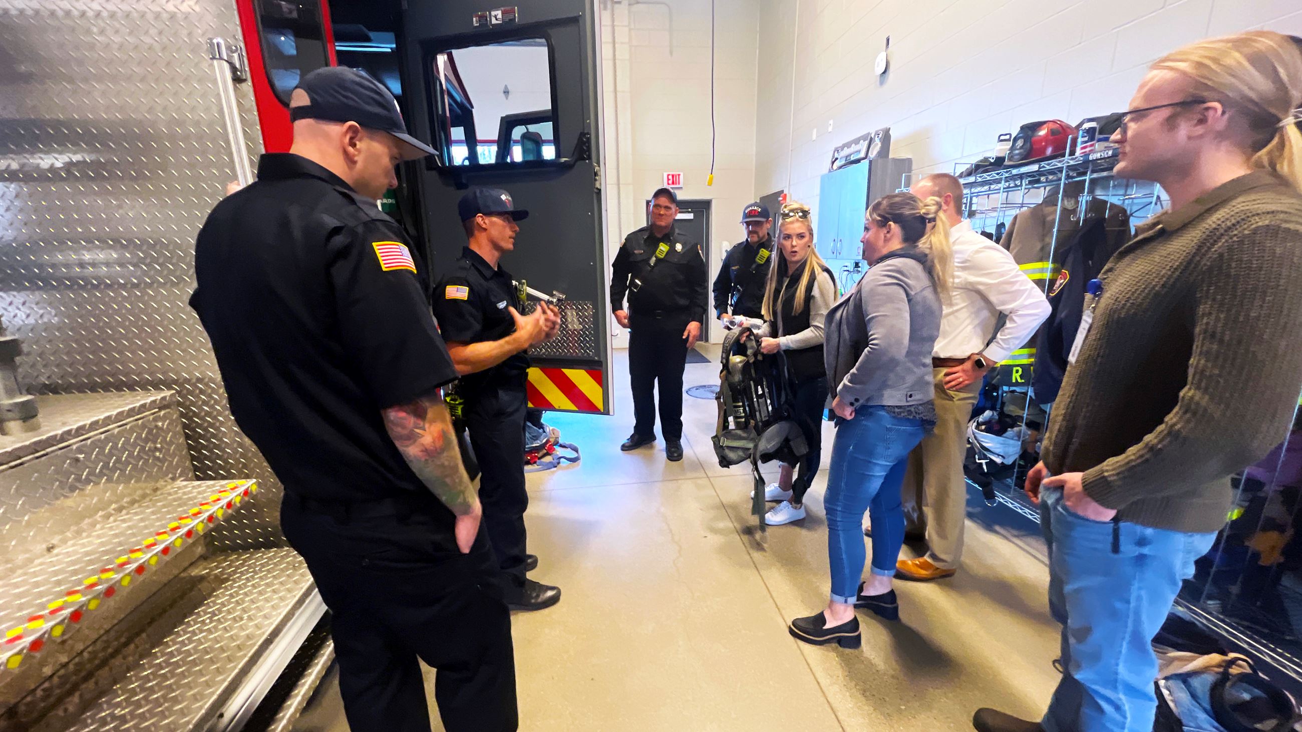Citizen Academy attendees test the weight of equipment to see what firefighters carry into a fire. 