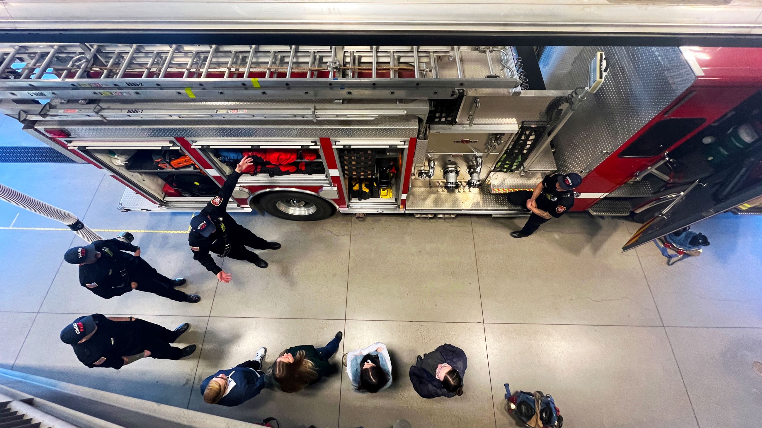 Firefighters explain how fire truck tools have evolved over time during a Citizen Academy tour. 
