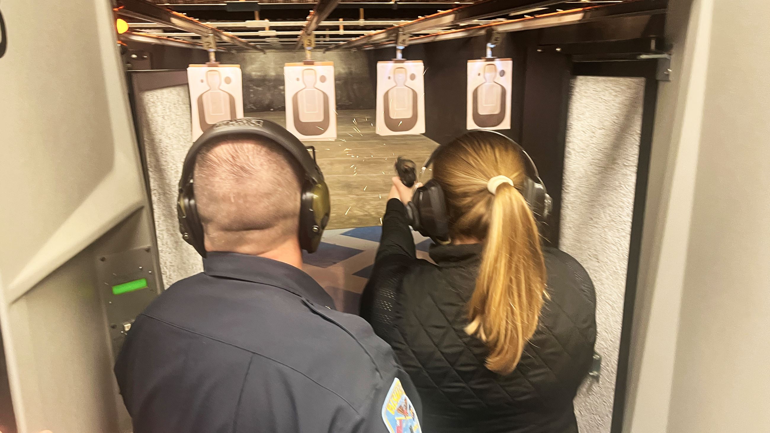 Citizen Academy attendees shoot at targets about 7 yards away, under officer guidance. 