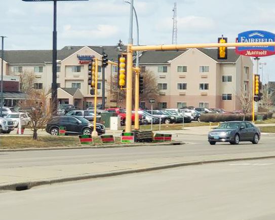 Advertising is displayed in city boulevards around a traffic light. 
